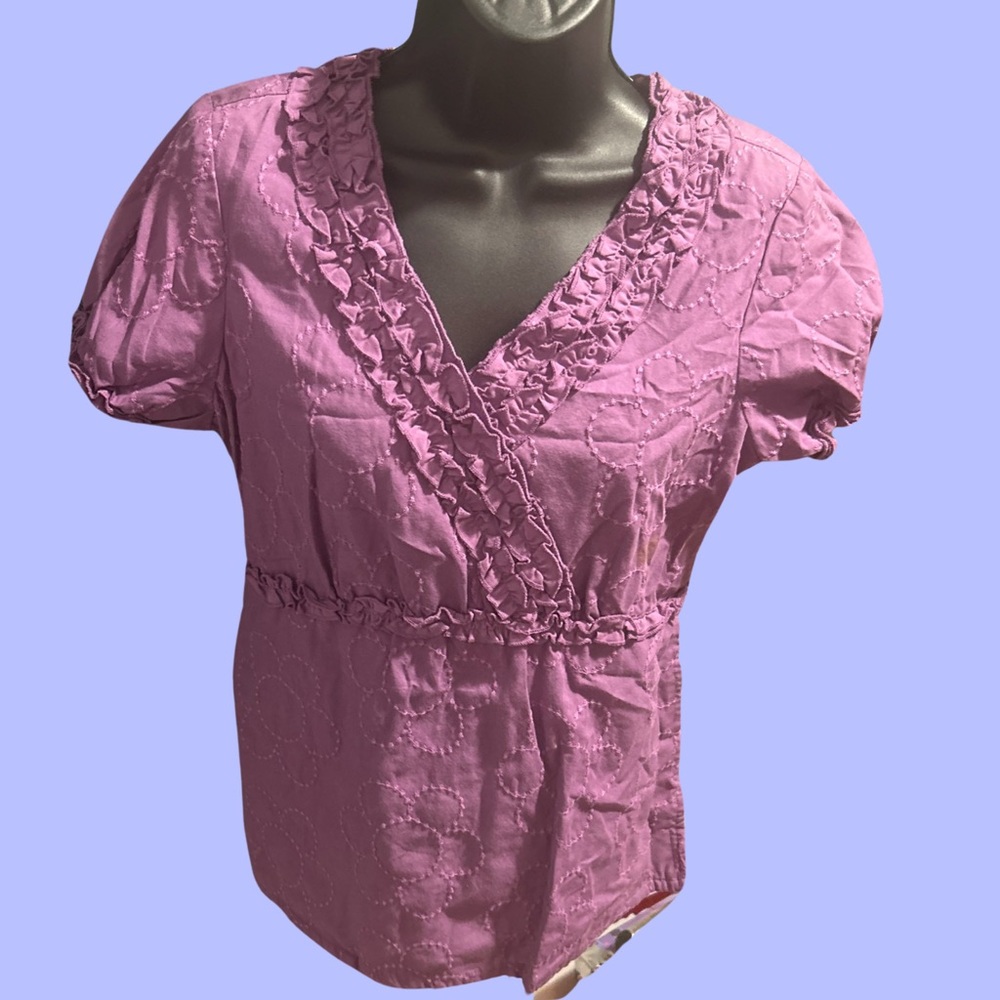 Nurse scrub top purple with ruffles and flower stitching all over.